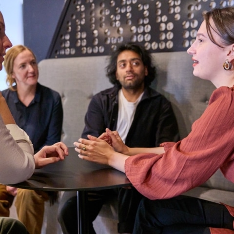 Four people discussing ideas around a table