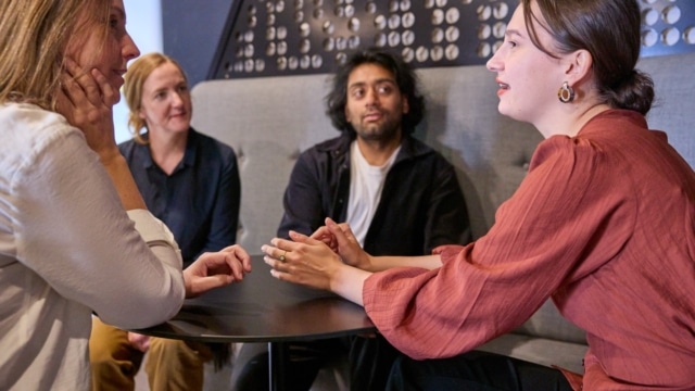 Four people discussing ideas around a table